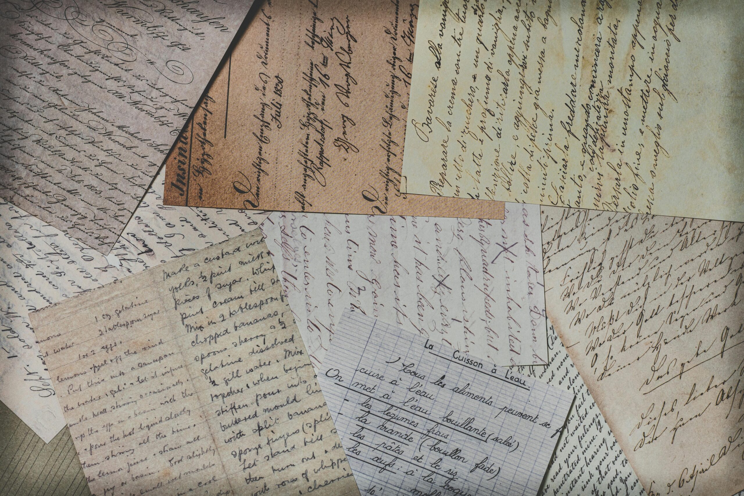 Close-up of various vintage handwritten letters on mixed paper textures, showcasing elegant penmanship.